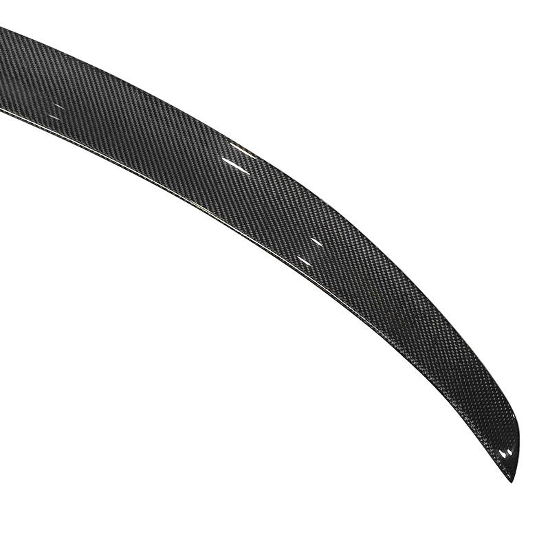 Pre-preg carbon fibre rear spoiler for BMW 4 Series on a plain background close up